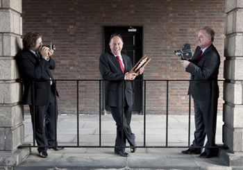 Barry’s Business to Arts Award (from left): Business to Arts’ Stuart McLaughlin ‘shoots’ Michael Barry of Barry & Fitzwilliam with the aid of Brendan Murphy of Allianz Ireland at Dublin Castle recently.