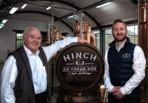 From left: Dr Terry Cross OBE with Aaron Flaherty, Hich Distillery's Head Distiller and the first new make spirit in the An Chead Dún cask.